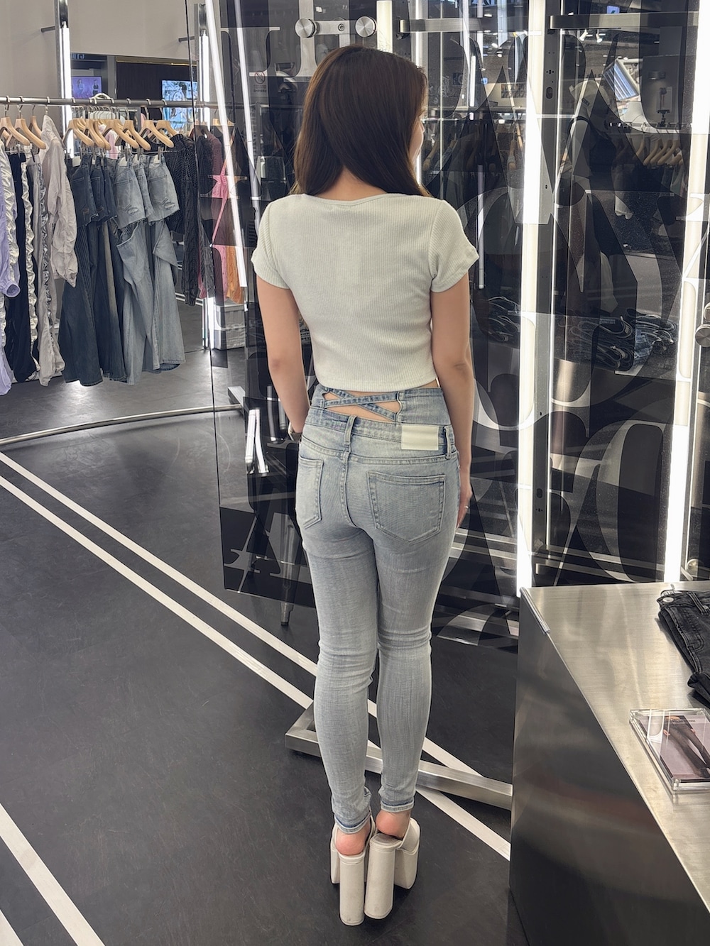 ホワイト系のサンダル、ブルー系のデニムパンツ、ホワイト系のTシャツ/カットソーを着用したレディースの春コーディネートの3枚目の写真