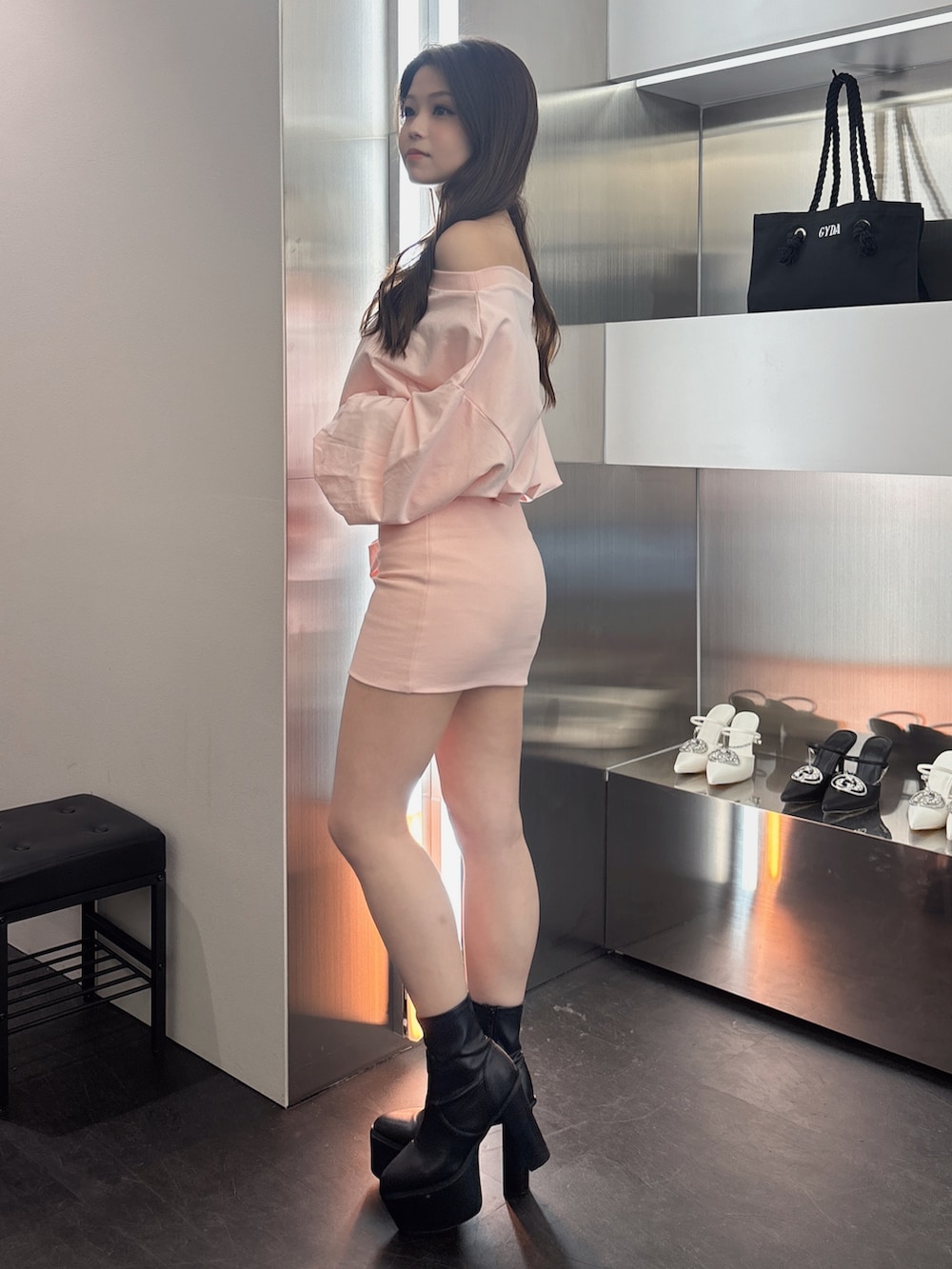 ピンク系のワンピース、ブラック系のブーツを着用したレディースの春コーディネートの2枚目の写真