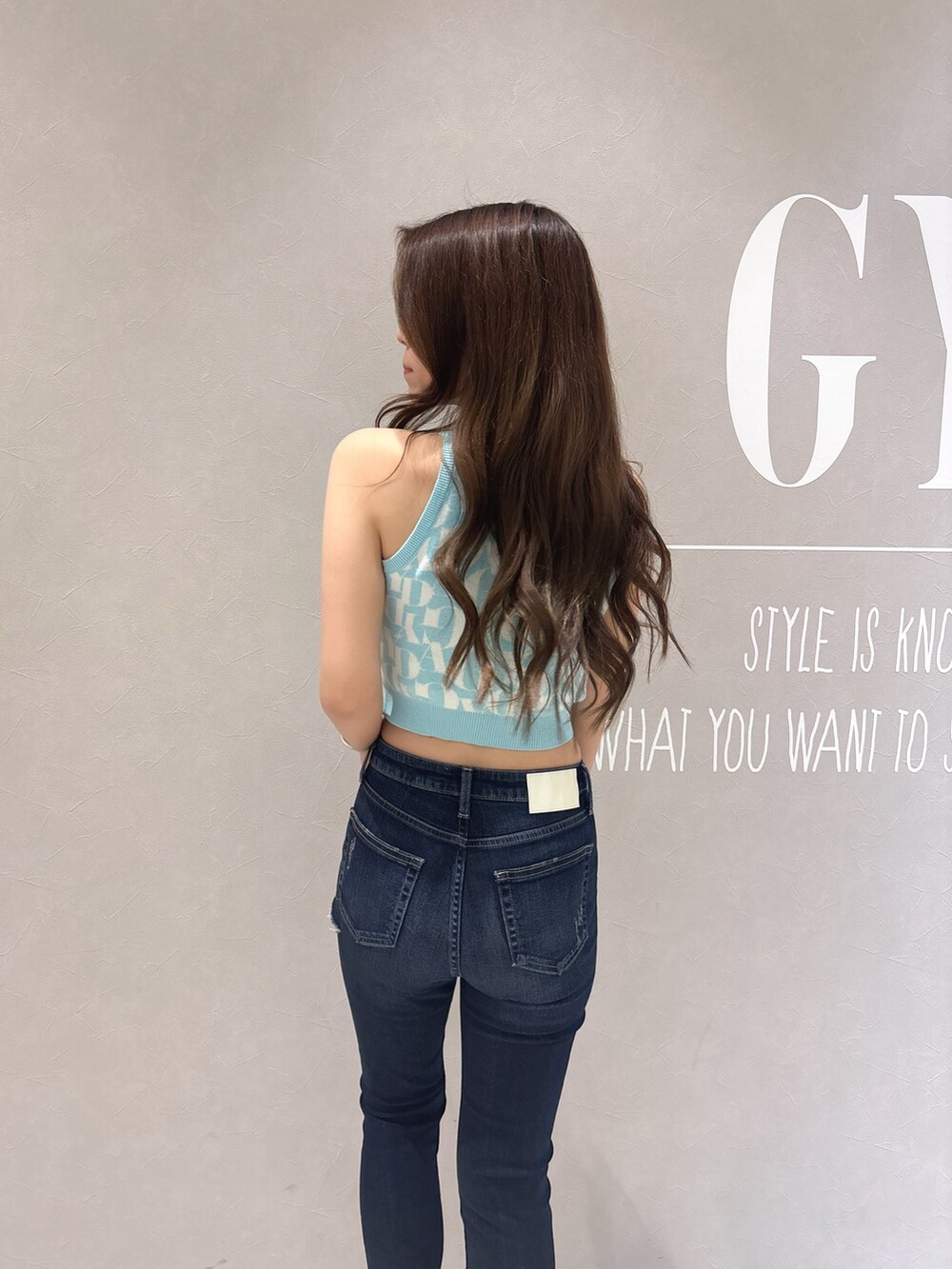 グリーン系のニット/セーター、ブルー系のデニムパンツ、ホワイト系のサンダルを着用したレディースの春コーディネートの7枚目の写真