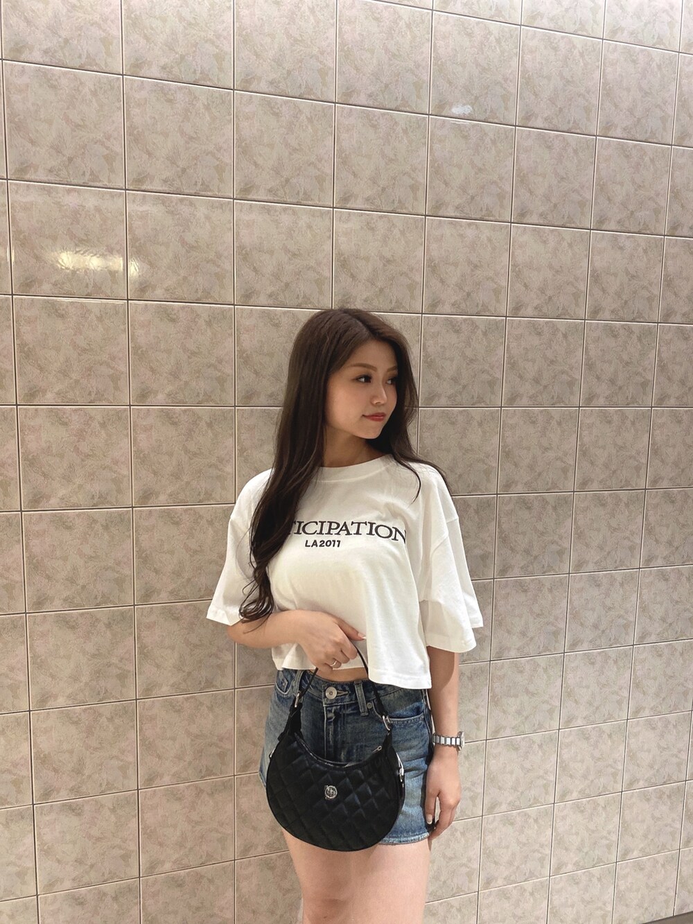 ホワイト系のTシャツ/カットソー、ブルー系のデニムスカート、ホワイト系のブーツを着用したレディースの夏コーディネートの5枚目の写真