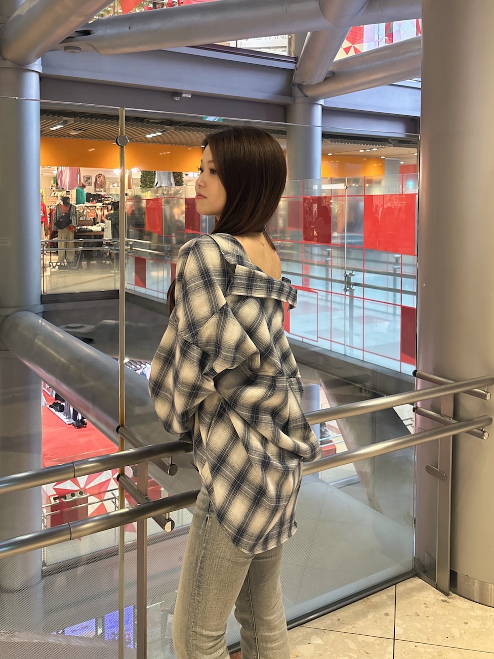 ホワイト系のキャミソール、ブルー系のデニムパンツ、ブラック系のブーツを着用したレディースの春コーディネートの5枚目の写真