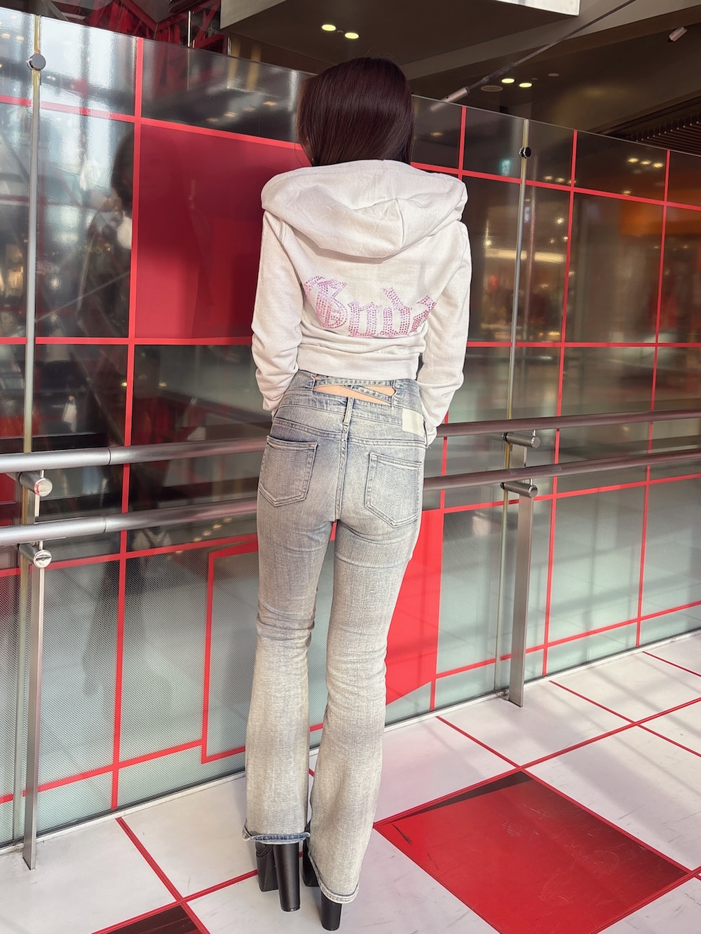 ホワイト系のパーカー、ブルー系のデニムパンツ、ブラック系のブーツを着用したレディースの冬コーディネートの3枚目の写真