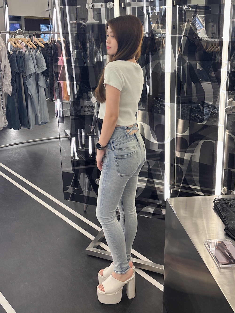 ホワイト系のサンダル、ブルー系のデニムパンツ、ホワイト系のTシャツ/カットソーを着用したレディースの春コーディネートの2枚目の写真