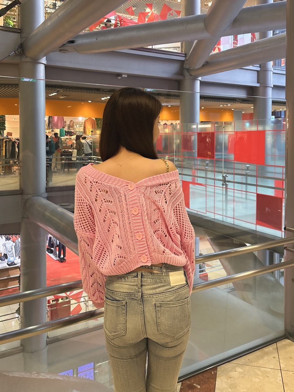 ピンク系のニット/セーター、ホワイト系のキャミソール、ブルー系のデニムパンツを着用したレディースの春コーディネートの6枚目の写真