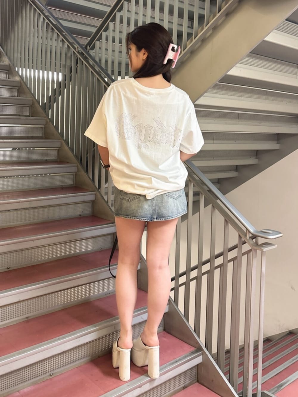 ピンク系のTシャツ/カットソー、ホワイト系のサンダル、ブラック系のハンドバッグを着用したレディースの夏コーディネートの3枚目の写真