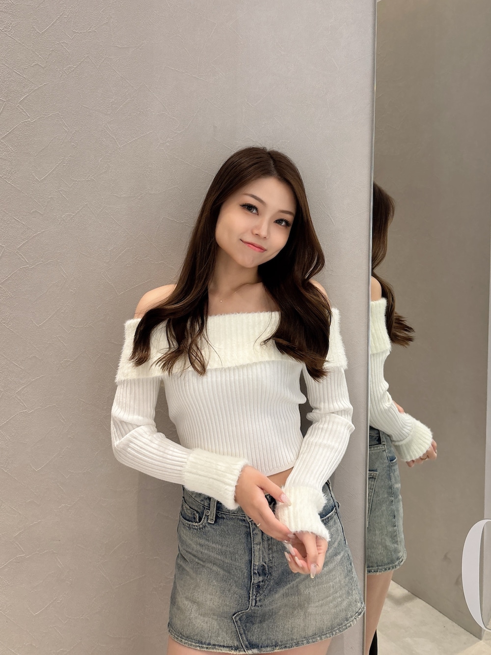 ホワイト系のニット/セーター、ブルー系のデニムスカート、ブラック系のブーツを着用したレディースの秋コーディネートの4枚目の写真