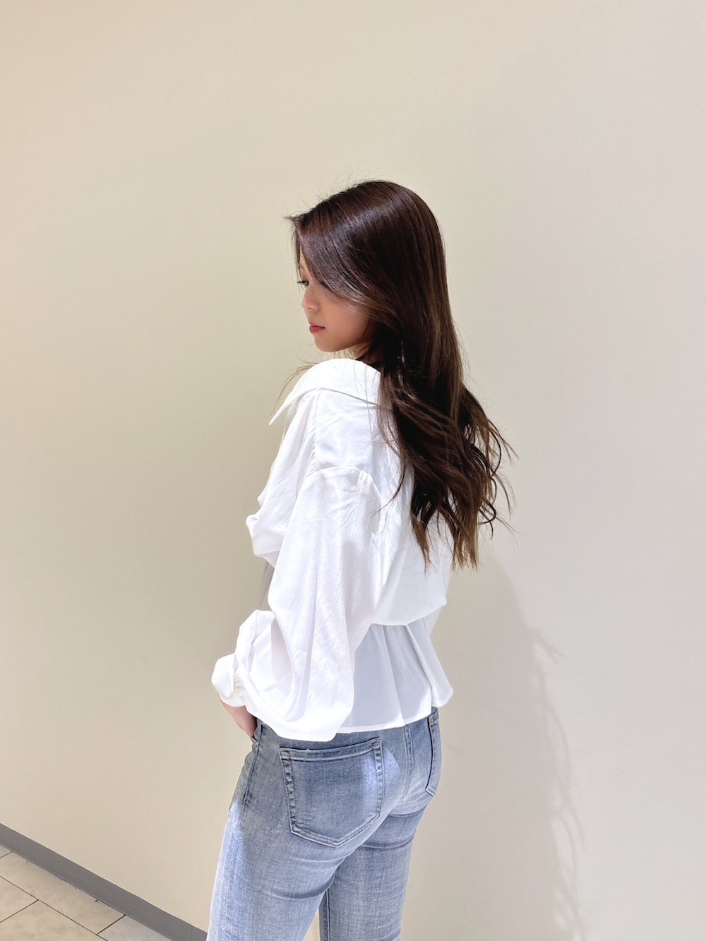 ホワイト系のシャツ/ブラウス、ブルー系のデニムパンツ、ホワイト系のパンプスを着用したレディースの冬コーディネートの9枚目の写真