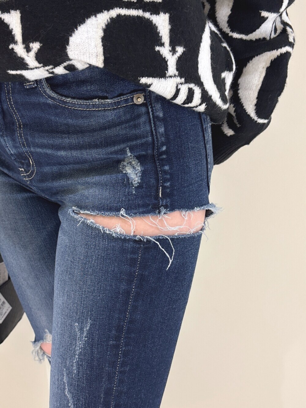 ホワイト系のパンプス、ブラック系のニット/セーター、ブルー系のデニムパンツを着用したレディースの冬コーディネートの10枚目の写真