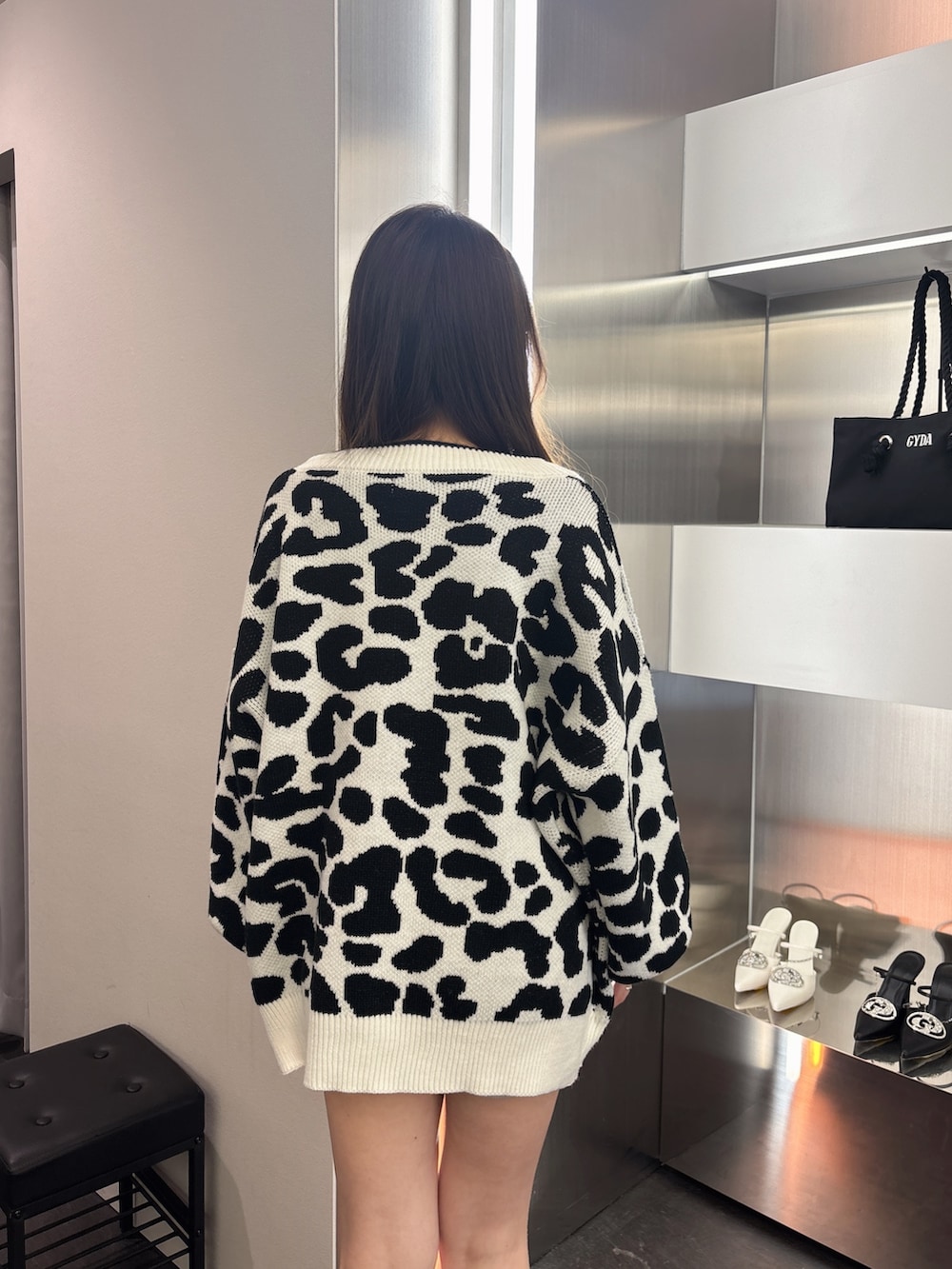 ブラック系のブーツ、ホワイト系のカーディガン/ボレロ、シルバー系のワンピースを着用したレディースの春コーディネートの6枚目の写真