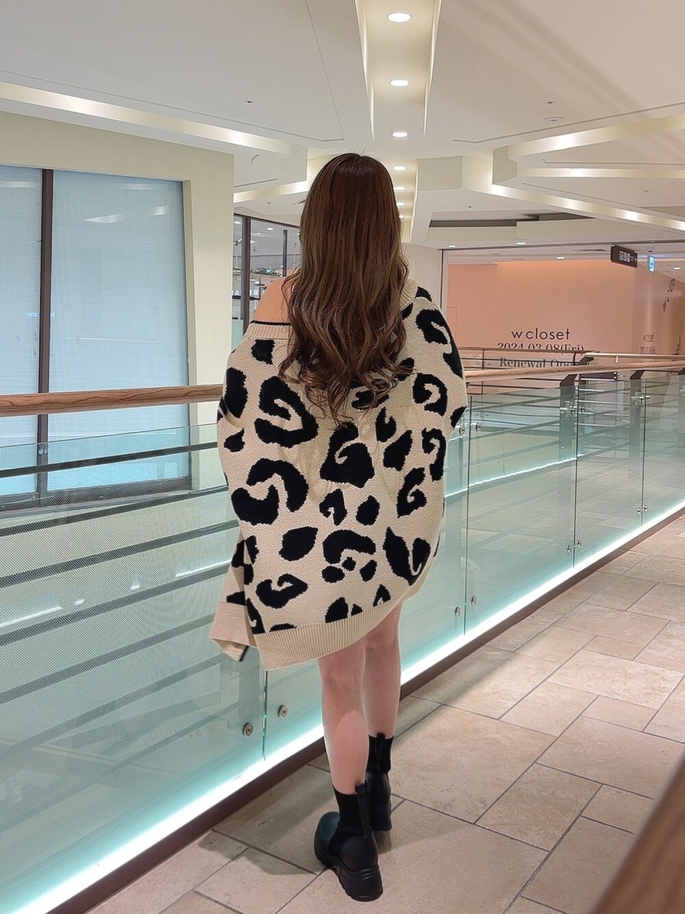 ベージュ系のカーディガン/ボレロ、ホワイト系のキャミソール、ブルー系のデニムスカートを着用したレディースの春コーディネートの4枚目の写真