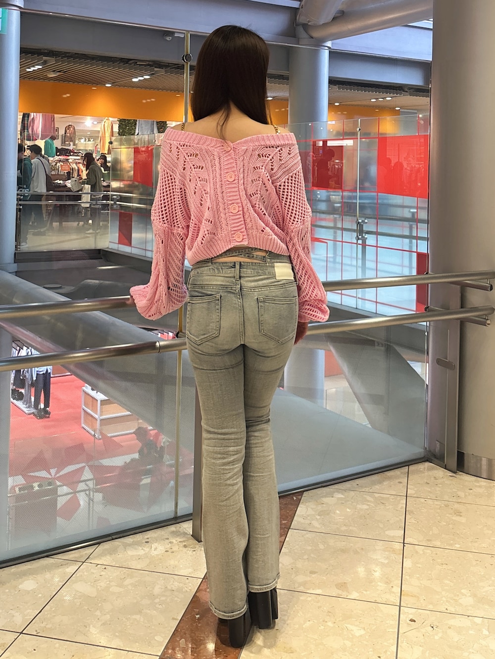 ピンク系のニット/セーター、ホワイト系のキャミソール、ブルー系のデニムパンツを着用したレディースの春コーディネートの3枚目の写真