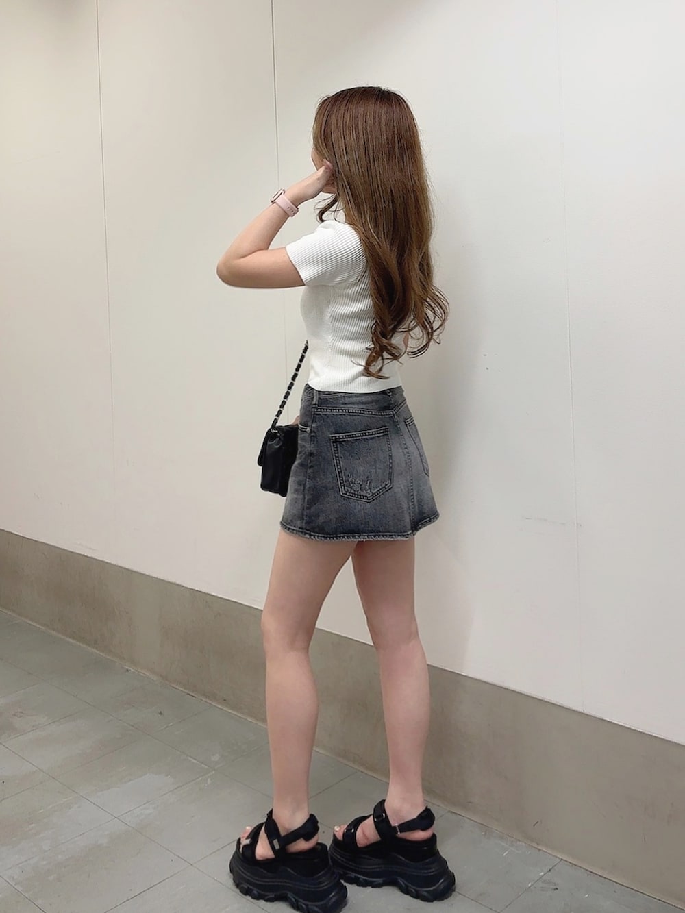 ホワイト系のTシャツ/カットソー、ブラック系のデニムスカート、ブラック系のサンダルを着用したレディースの春コーディネートの3枚目の写真