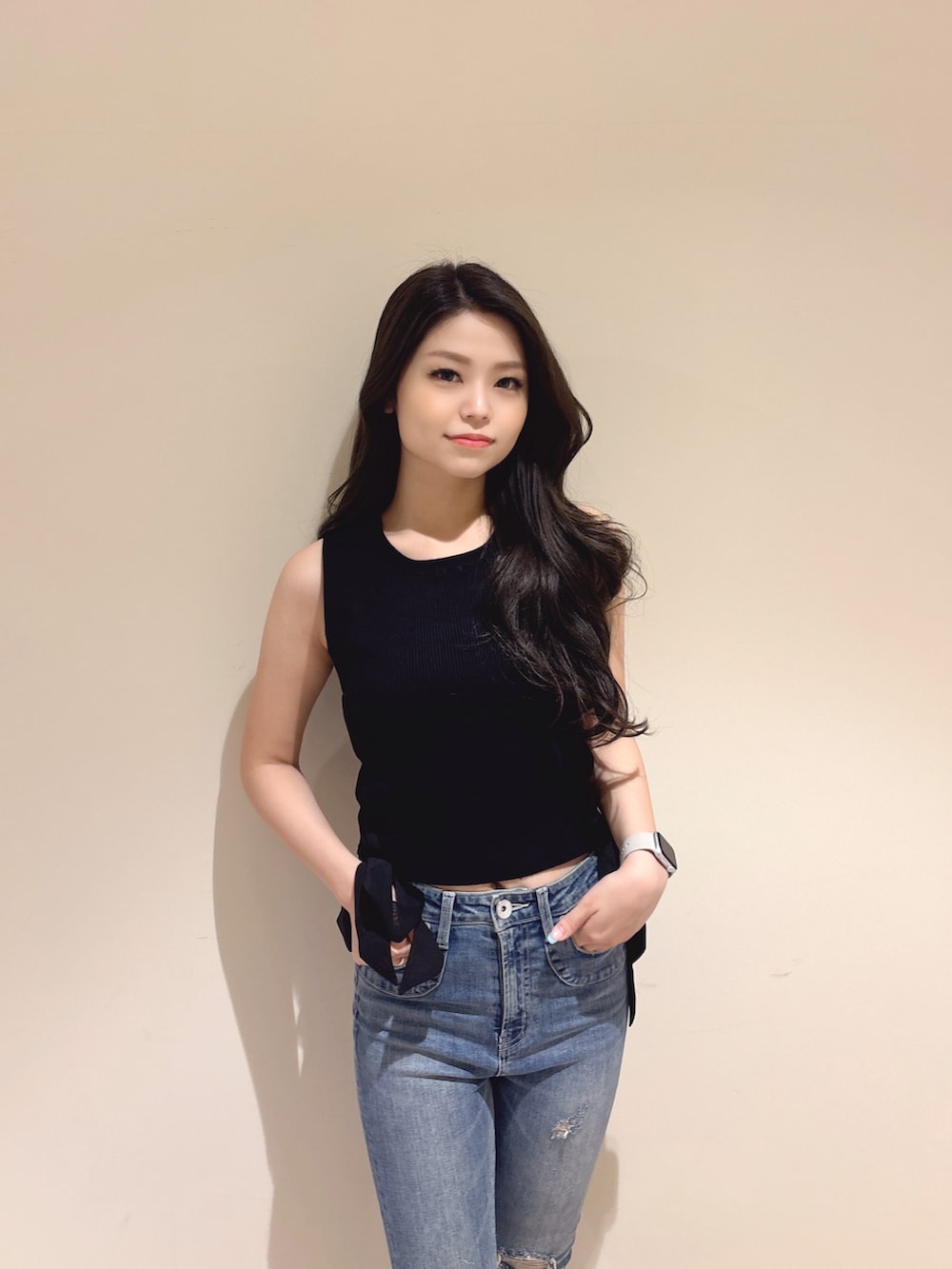 ブラック系のニット/セーター、ブルー系のデニムパンツ、ホワイト系のパンプスを着用したレディースの夏コーディネートの5枚目の写真