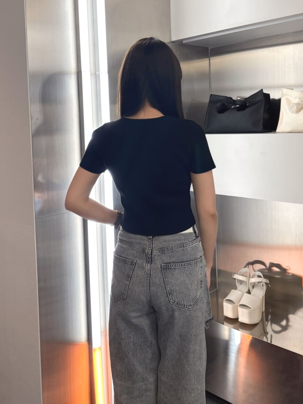 ホワイト系のTシャツ/カットソー、ホワイト系のサンダル、ブルー系のデニムパンツを着用したレディースの春コーディネートの5枚目の写真