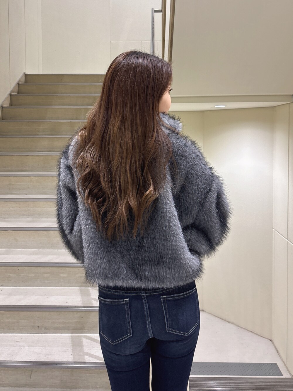 グレー系のその他アウター、ブルー系のデニムパンツ、ブラック系のパンプスを着用したレディースの冬コーディネートの8枚目の写真