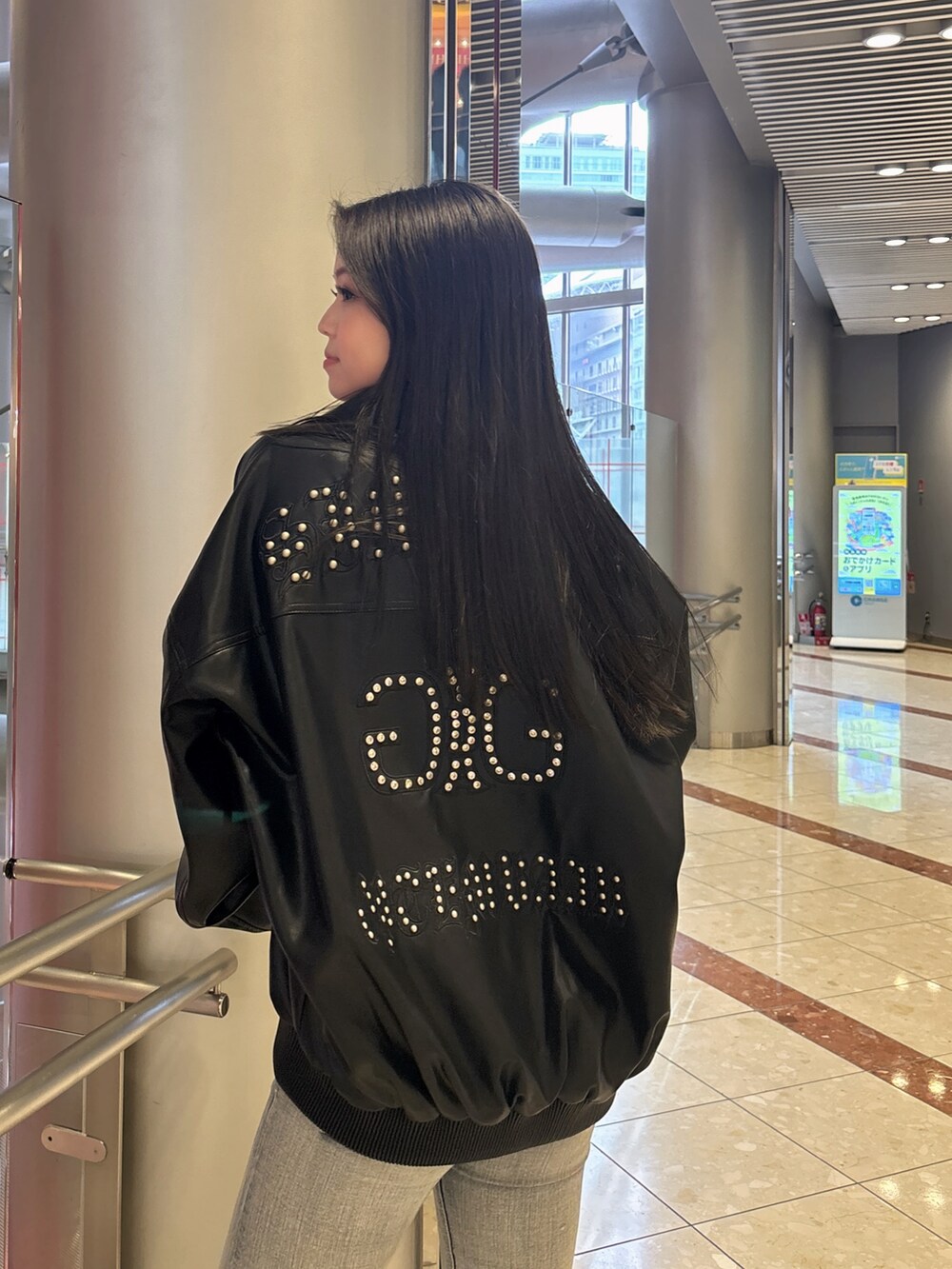 ブラック系のブルゾン、ブルー系のデニムパンツ、ブラック系のブーツを着用したレディースの春コーディネートの6枚目の写真