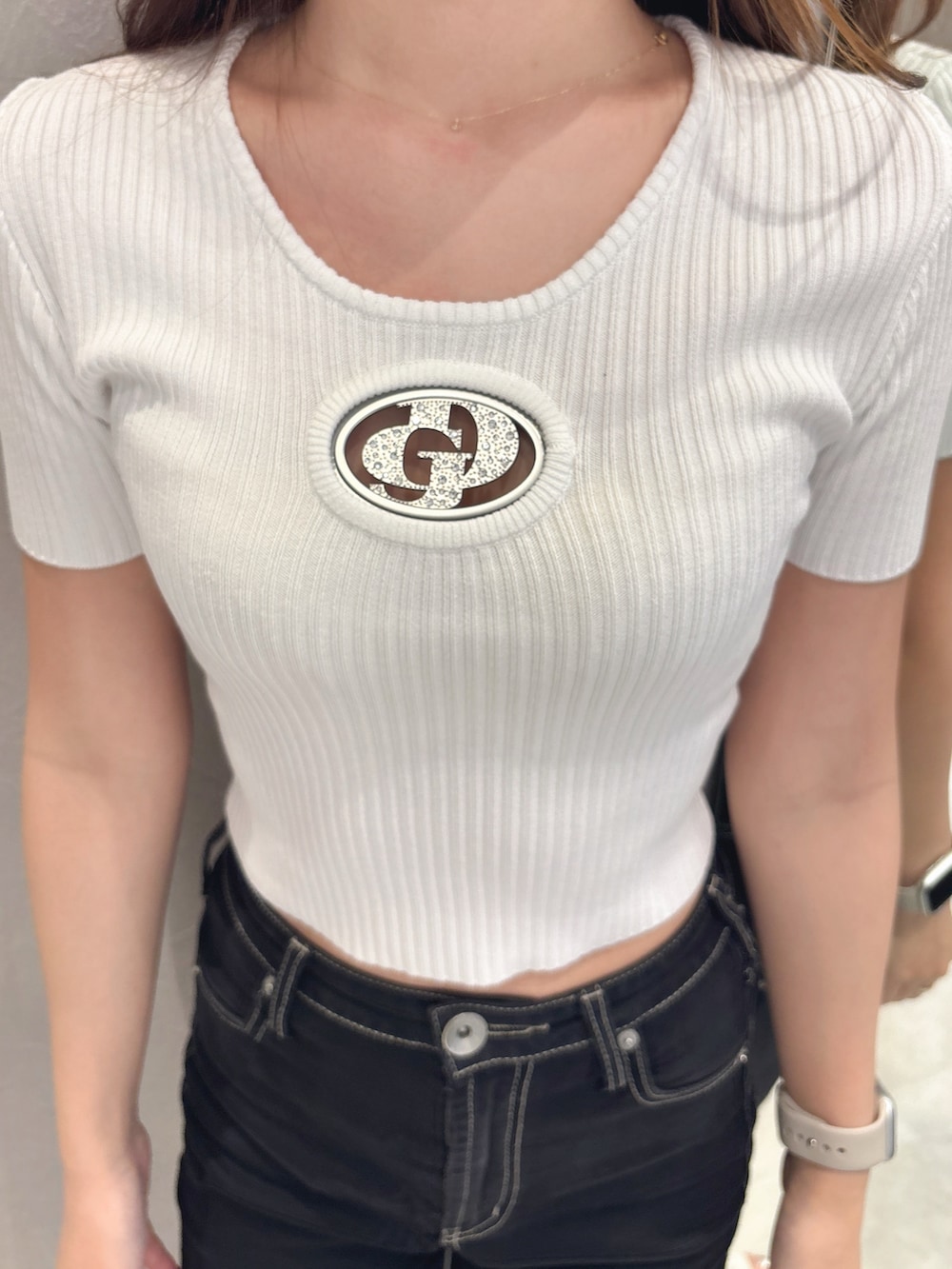 ホワイト系のニット/セーター、ブラック系のデニムパンツ、ホワイト系のサンダルを着用したレディースの夏コーディネートの6枚目の写真