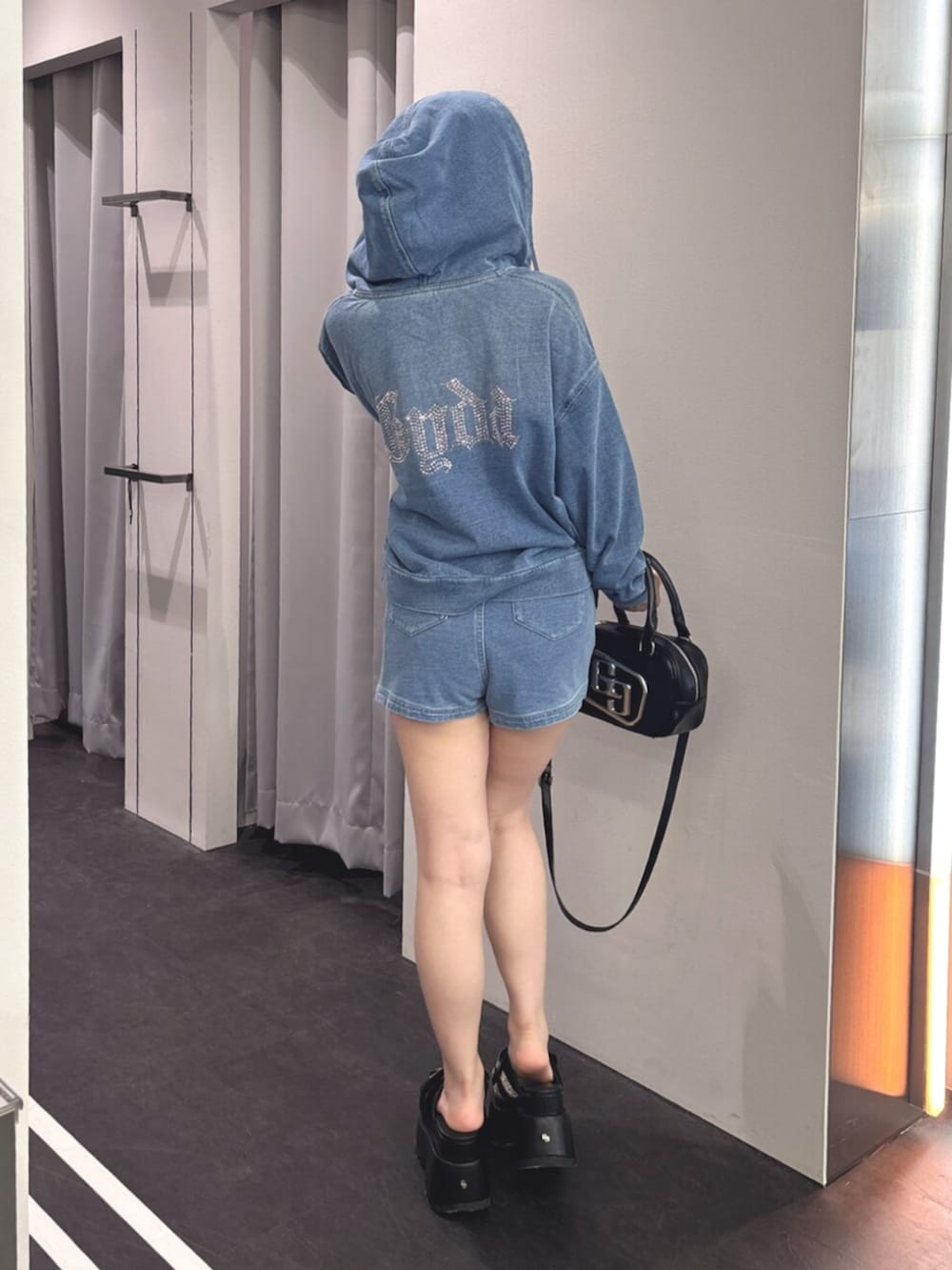 ブラック系のハンドバッグ、ブルー系のパーカー、ブルー系のその他パンツを着用したレディースの夏コーディネートの3枚目の写真