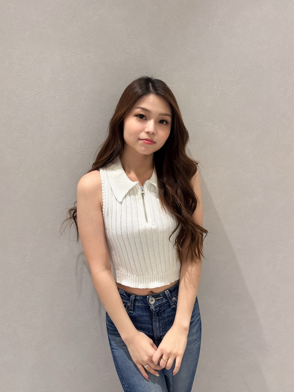 ホワイト系のニット/セーター、ブルー系のデニムパンツ、ホワイト系のパンプスを着用したレディースの夏コーディネートの4枚目の写真