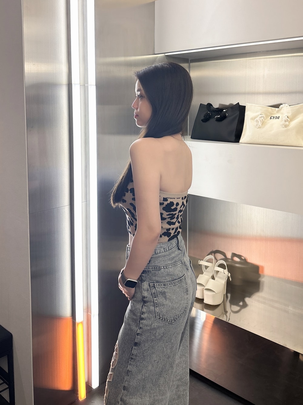 その他のキャミソール、ブルー系のデニムパンツ、ホワイト系のサンダルを着用したレディースの春コーディネートの5枚目の写真