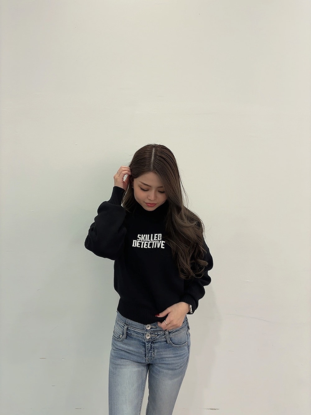 ブラック系のニット/セーター、ブルー系のデニムパンツ、ブラック系のブーツを着用したレディースの冬コーディネートの2枚目の写真