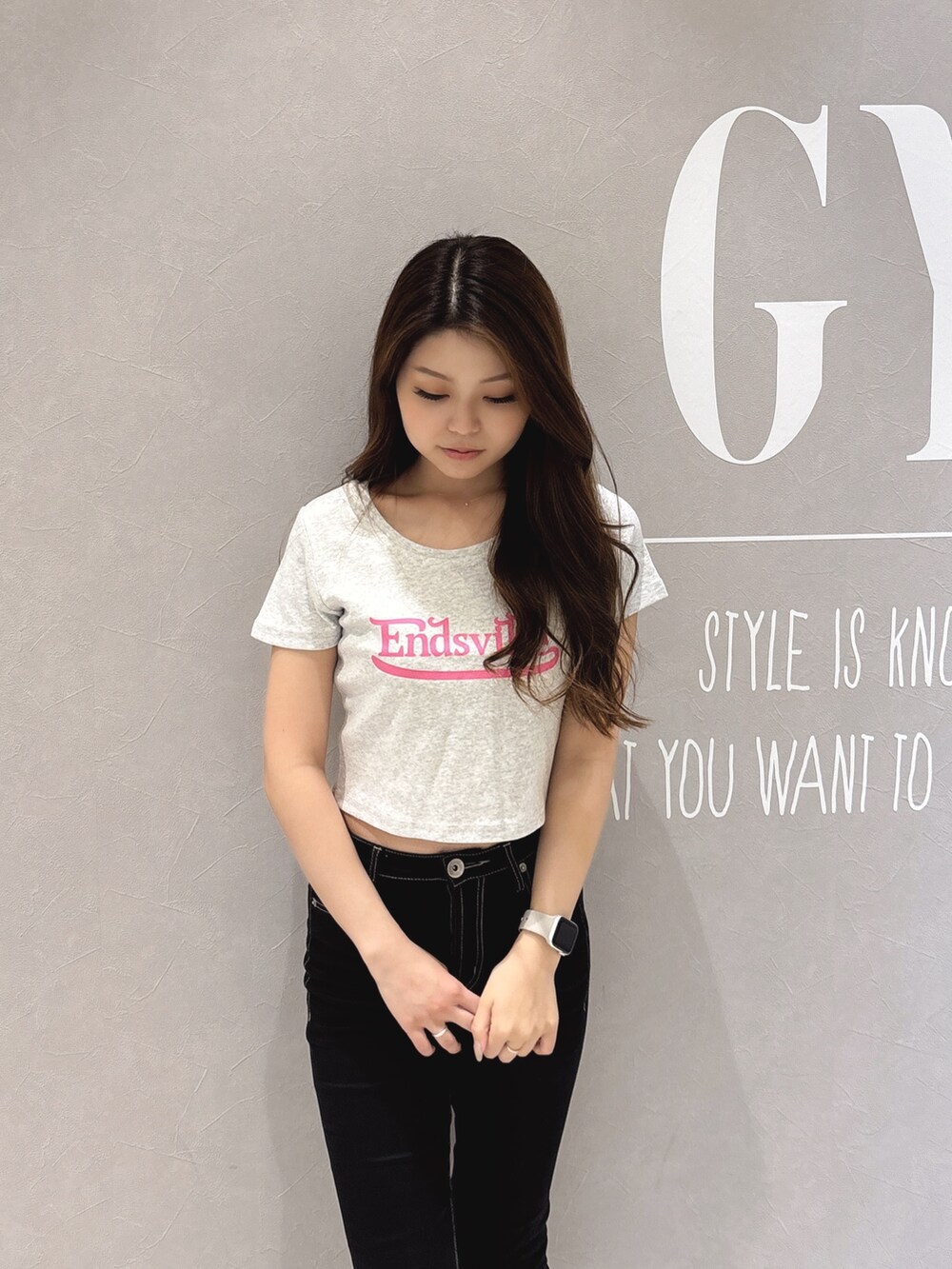 グレー系のTシャツ/カットソー、ブラック系のデニムパンツ、ホワイト系のパンプスを着用したレディースの春コーディネートの5枚目の写真