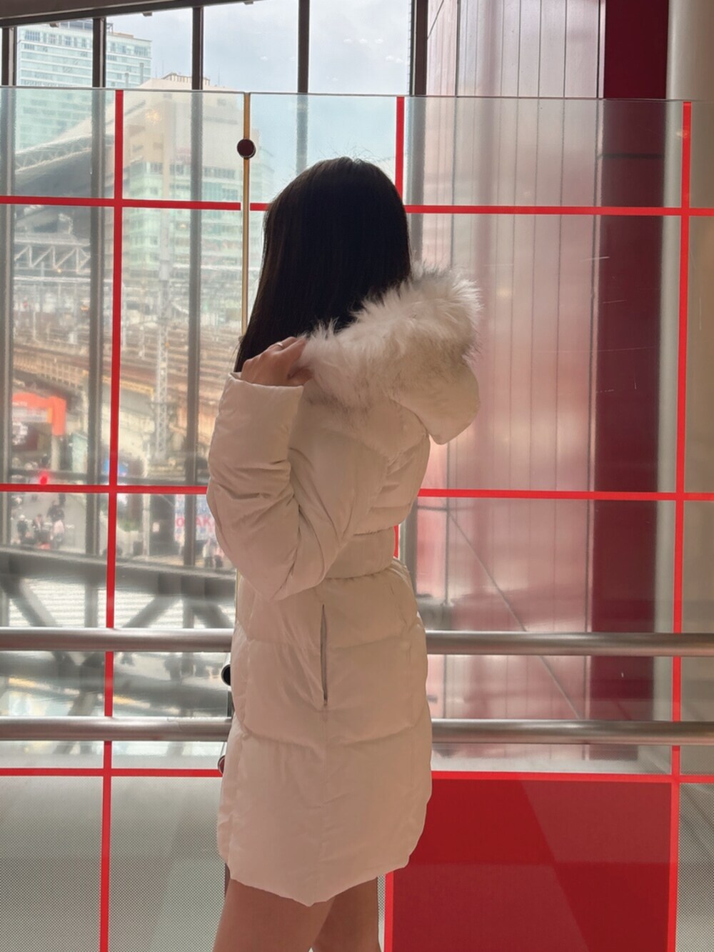 ブラック系のブーツ、ホワイト系のダウンジャケット/コートを着用したレディースの冬コーディネートの5枚目の写真