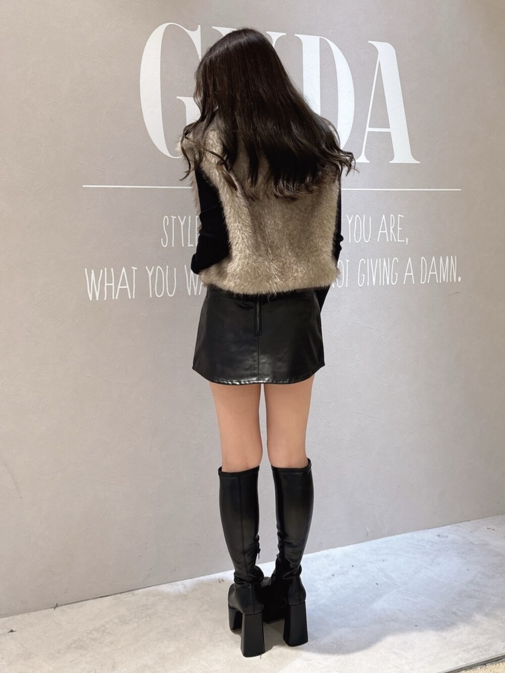 ブラック系のニット/セーター、ブラック系のスカート、ブラック系のブーツを着用したレディースの秋コーディネートの3枚目の写真