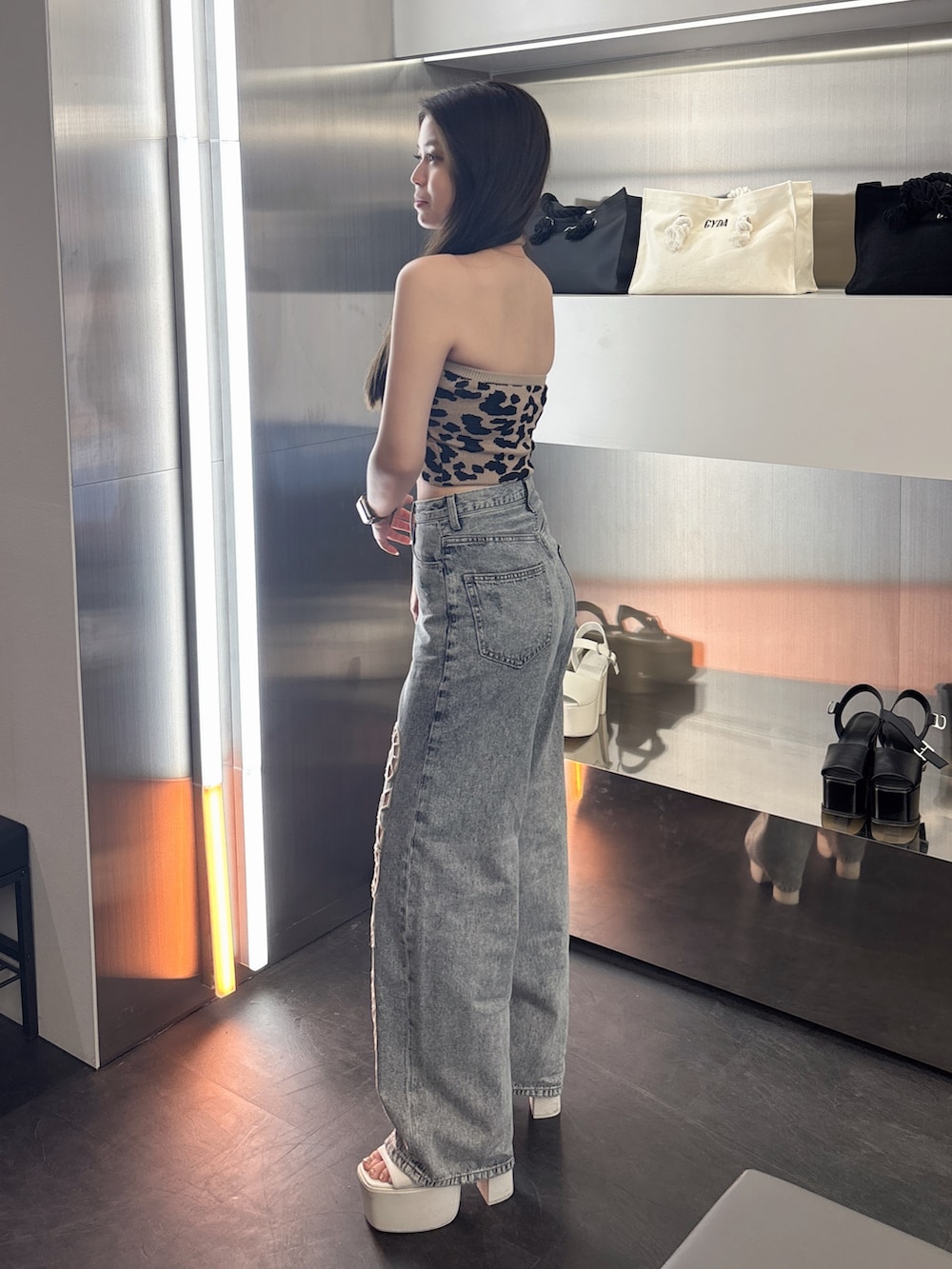 その他のキャミソール、ブルー系のデニムパンツ、ホワイト系のサンダルを着用したレディースの春コーディネートの2枚目の写真