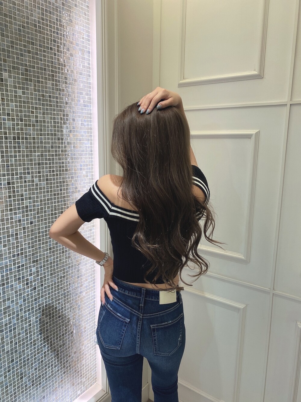 ブラック系のニット/セーター、ブルー系のデニムパンツ、ブラック系のパンプスを着用したレディースの夏コーディネートの5枚目の写真