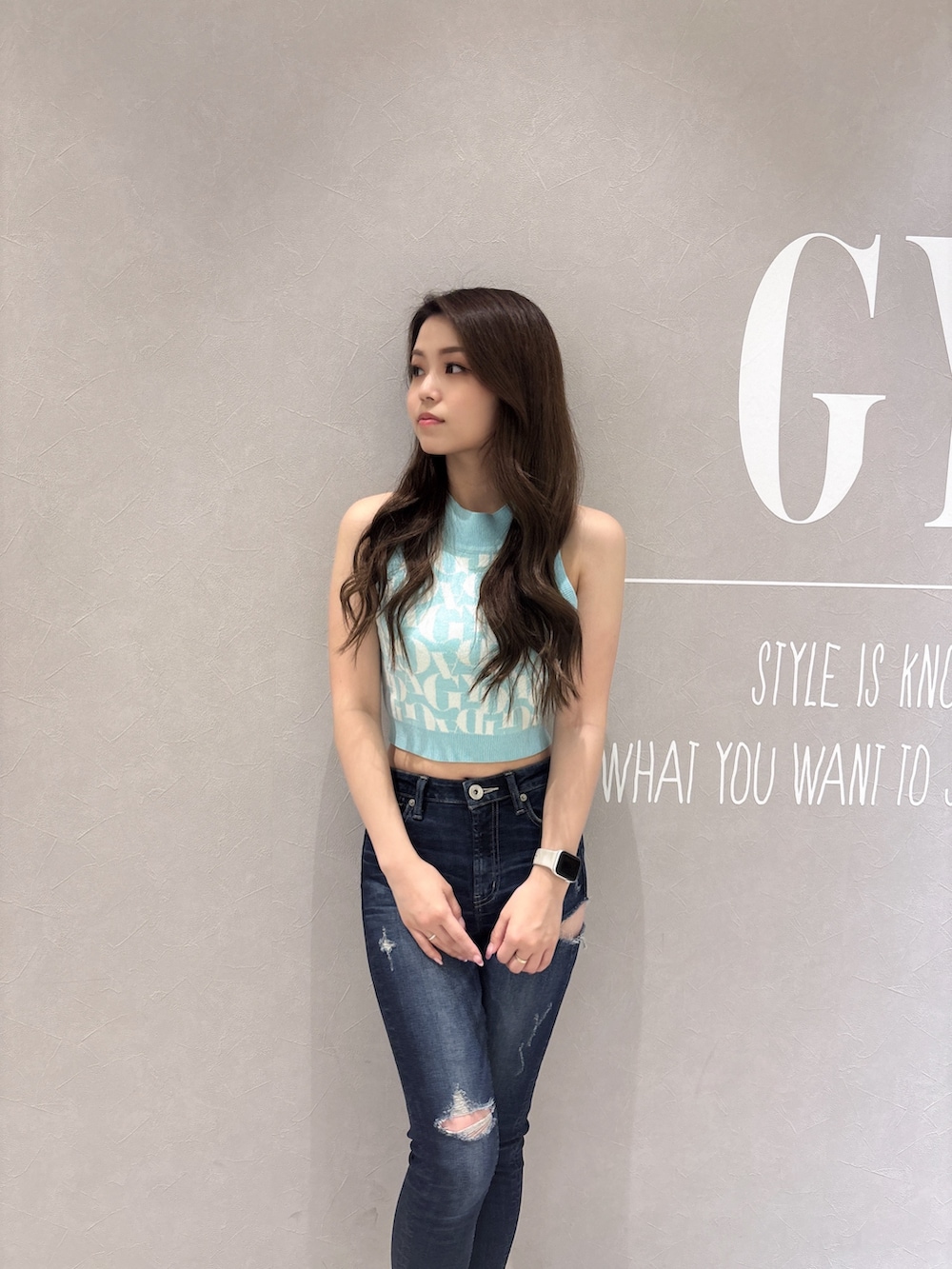 グリーン系のニット/セーター、ブルー系のデニムパンツ、ホワイト系のサンダルを着用したレディースの春コーディネートの5枚目の写真