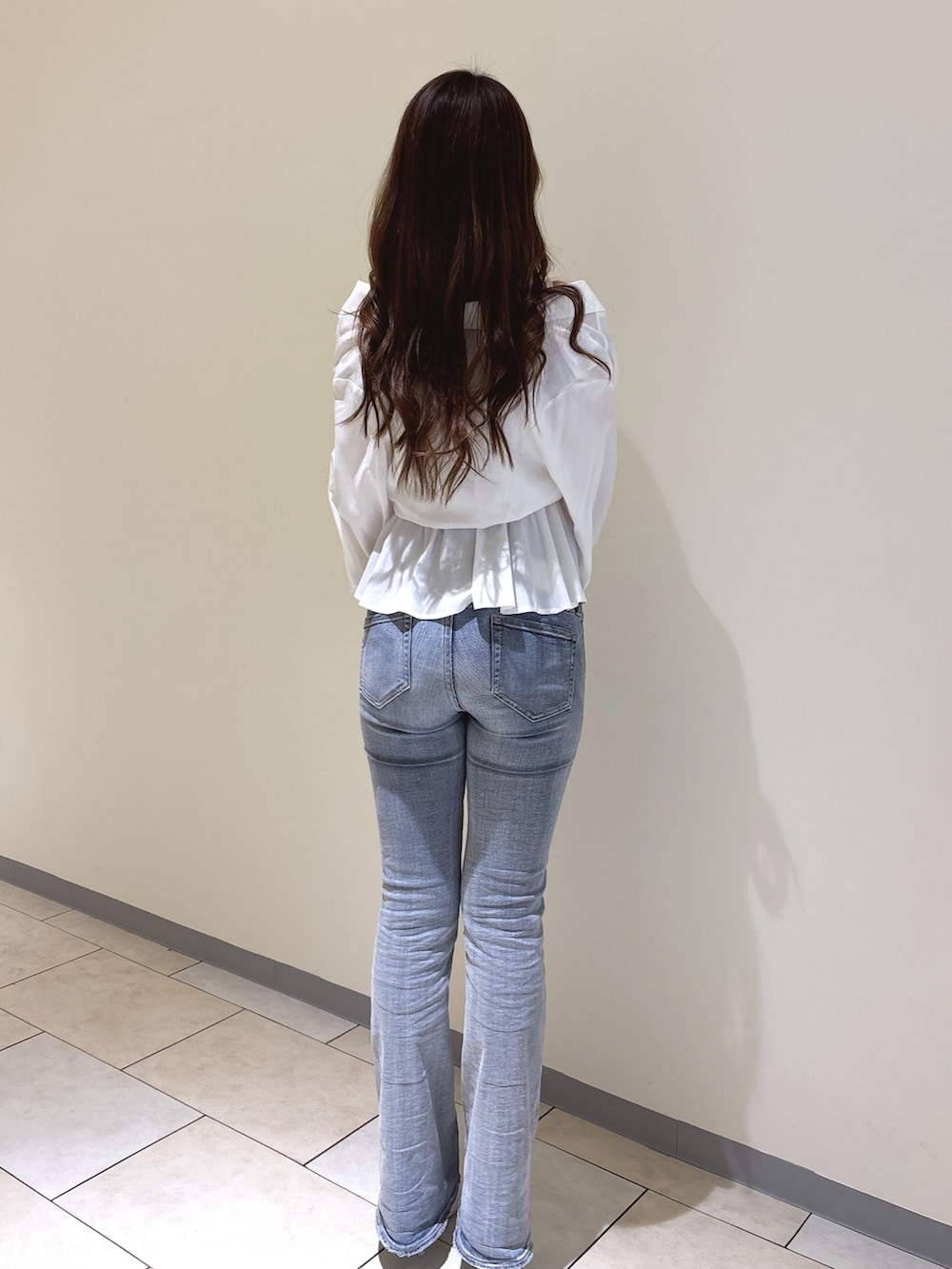 ホワイト系のシャツ/ブラウス、ブルー系のデニムパンツ、ホワイト系のパンプスを着用したレディースの冬コーディネートの5枚目の写真