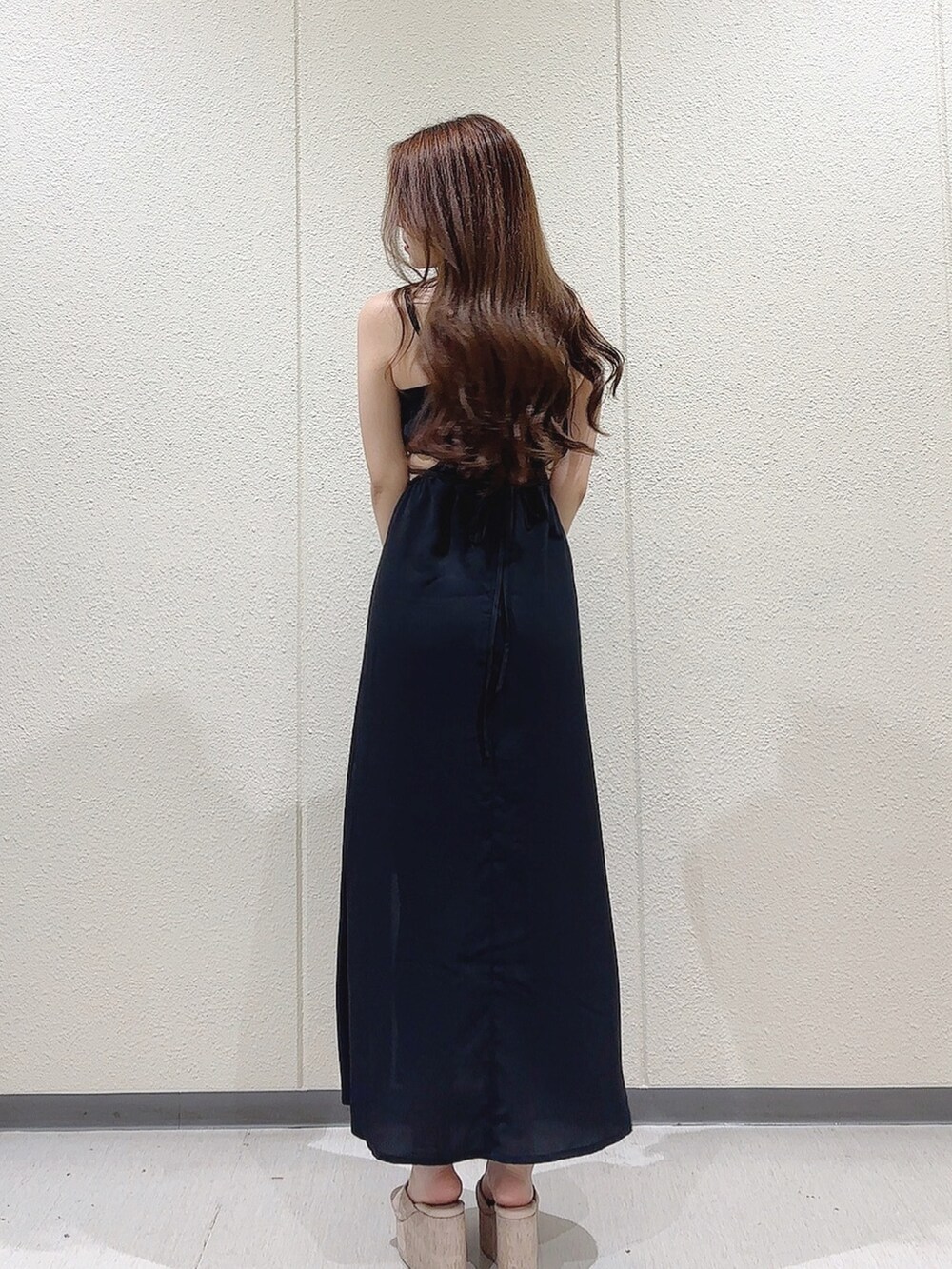 ブラック系のワンピース、ブラック系のショルダーバッグ、ホワイト系のサンダルを着用したレディースの夏コーディネートの4枚目の写真