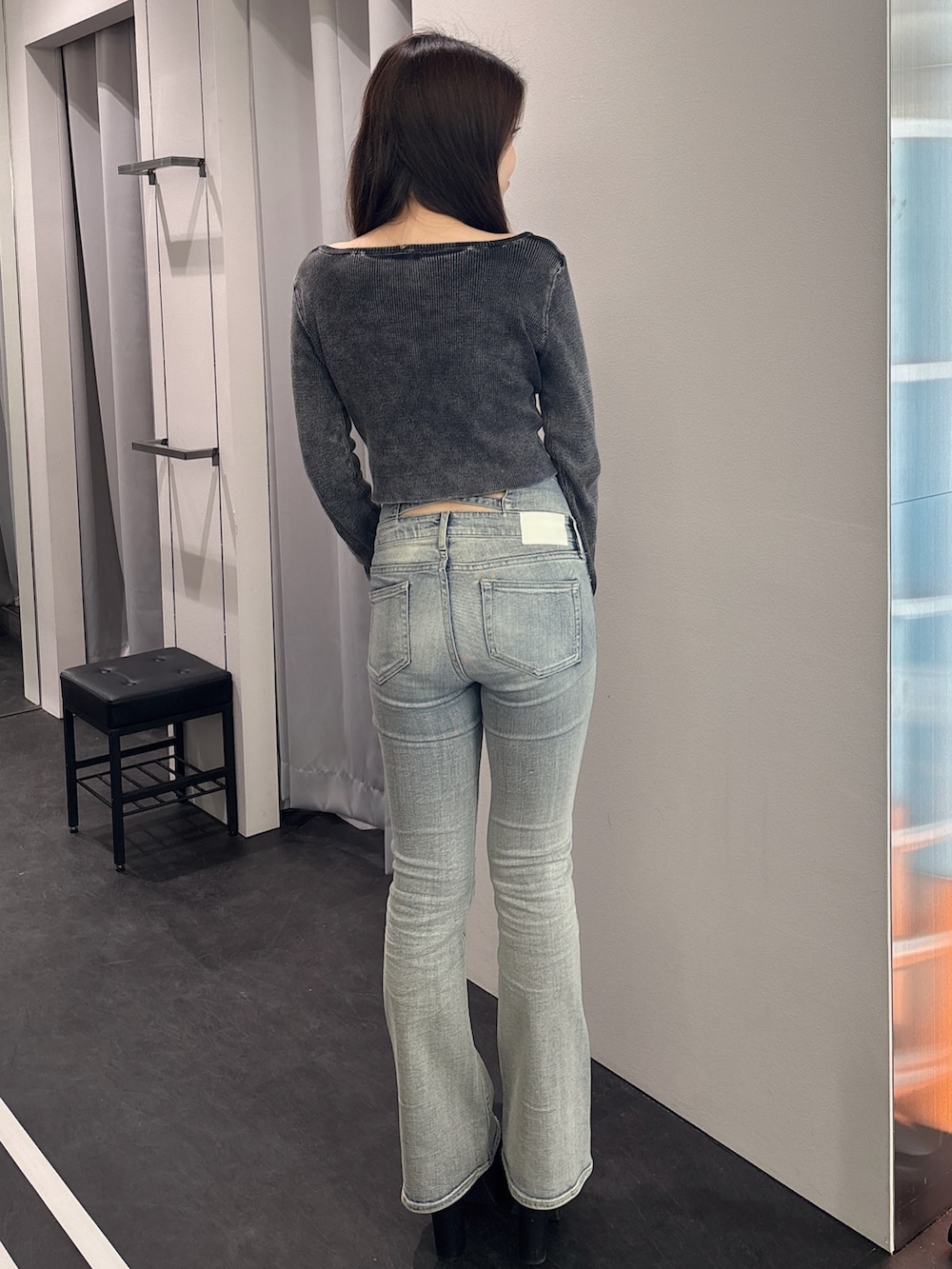 ブラック系のニット/セーター、ブルー系のデニムパンツ、ブラック系のブーツを着用したレディースの春コーディネートの3枚目の写真