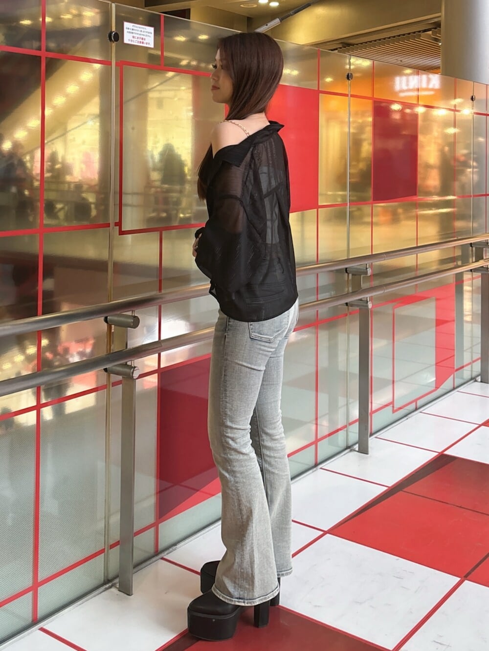 ブラック系のブーツ、ブルー系のデニムパンツ、ホワイト系のキャミソールを着用したレディースの春コーディネートの2枚目の写真