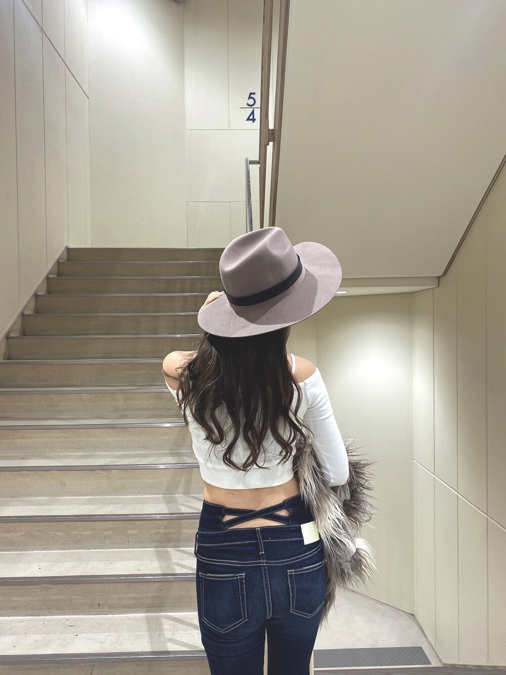 ホワイト系のTシャツ/カットソー、その他のベスト、ブルー系のデニムパンツを着用したレディースの秋コーディネートの6枚目の写真