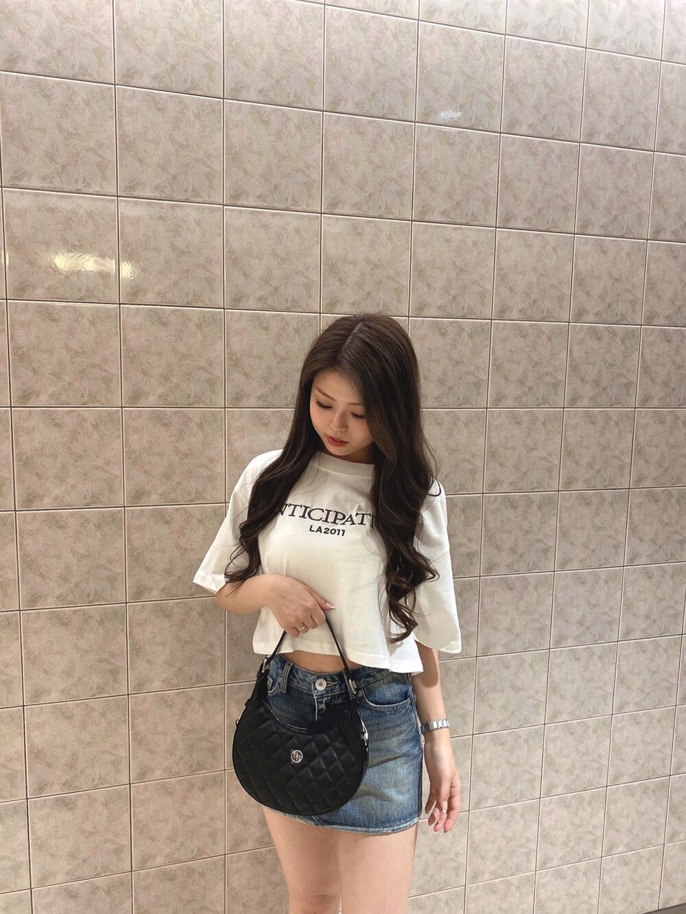 ホワイト系のTシャツ/カットソー、ブルー系のデニムスカート、ホワイト系のブーツを着用したレディースの夏コーディネートの4枚目の写真