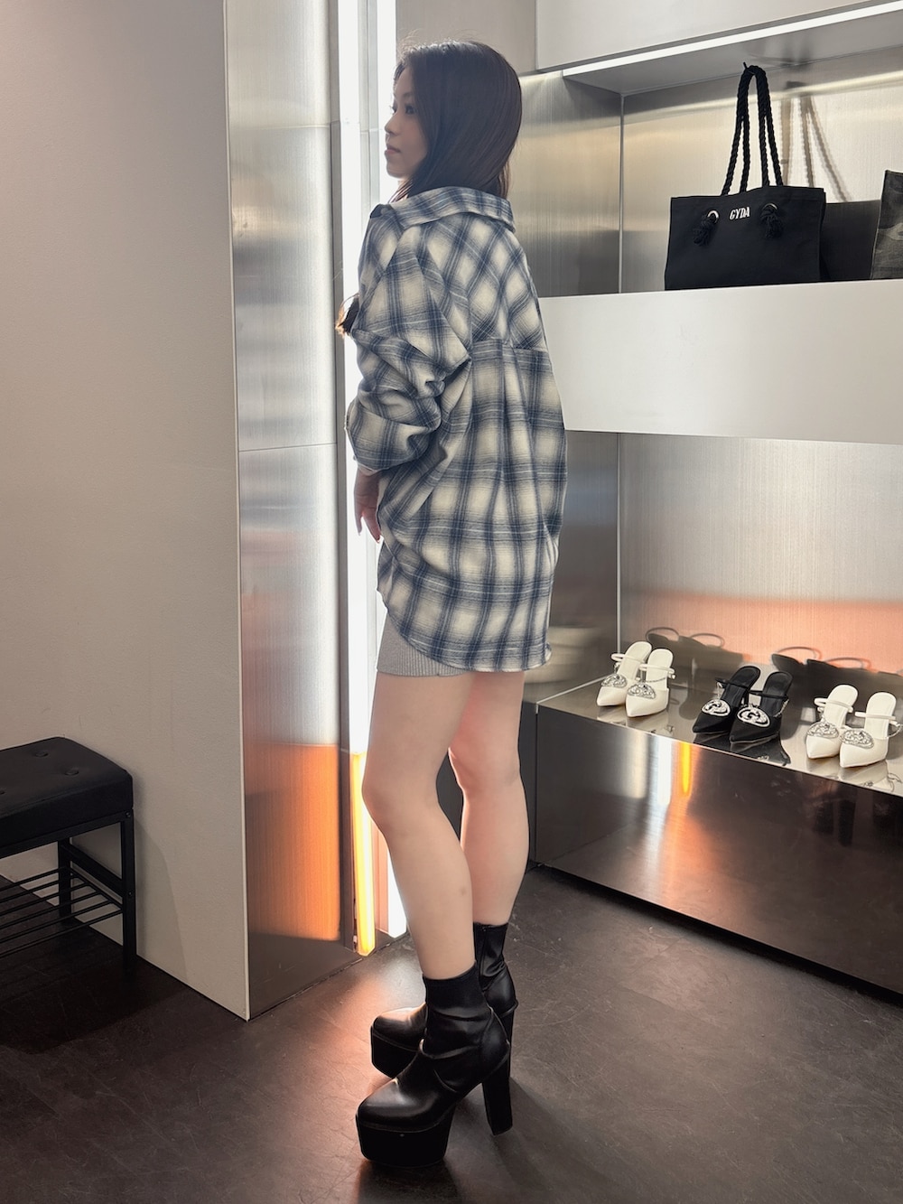 シルバー系のワンピース、ブルー系のシャツ/ブラウス、ブラック系のブーツを着用したレディースの春コーディネートの2枚目の写真