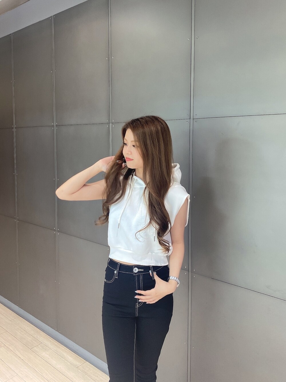 ホワイト系のパーカー、ブラック系のデニムパンツ、ホワイト系のサンダルを着用したレディースの夏コーディネートの4枚目の写真