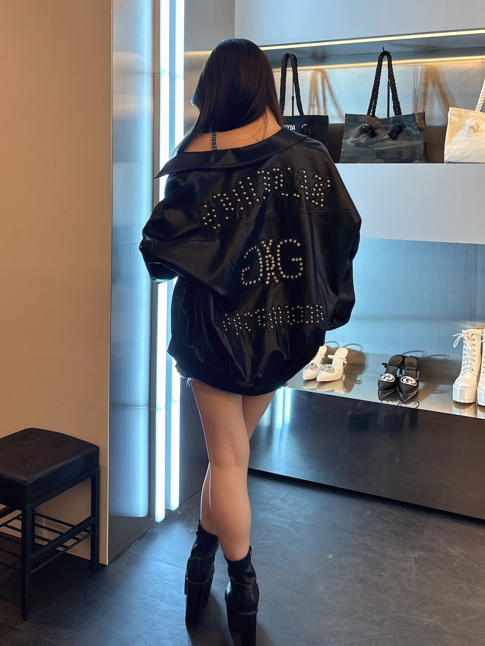 ブルー系のデニムジャケット、ブラック系のブルゾン、ブラック系のブーツを着用したレディースの春コーディネートの3枚目の写真