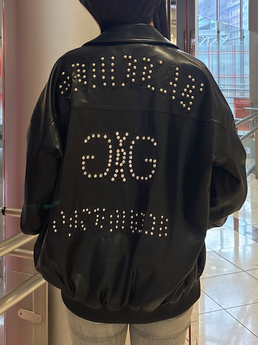 ブラック系のブルゾン、ブルー系のデニムパンツ、ブラック系のブーツを着用したレディースの春コーディネートの7枚目の写真