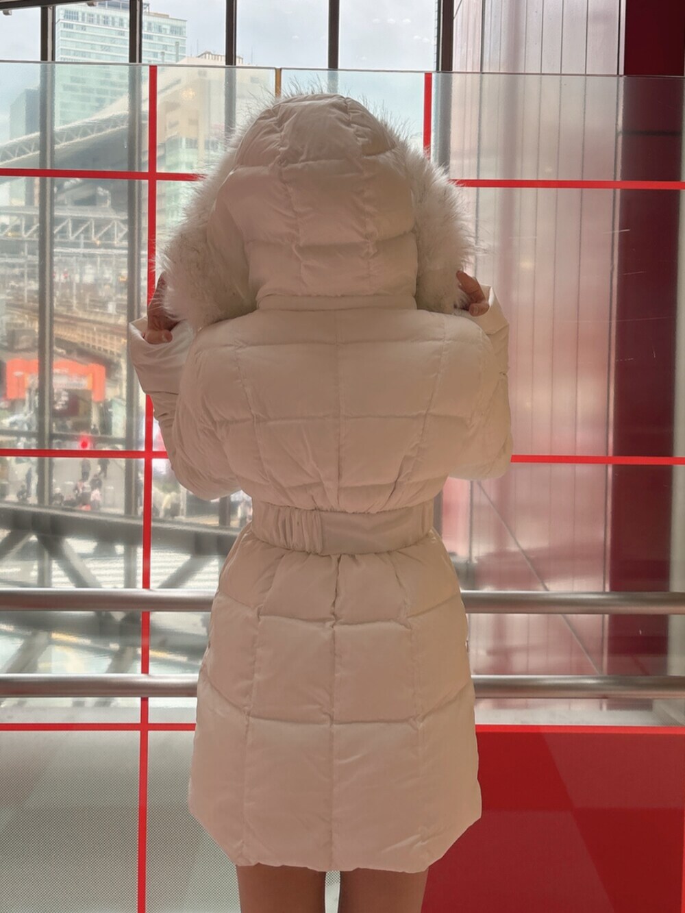 ブラック系のブーツ、ホワイト系のダウンジャケット/コートを着用したレディースの冬コーディネートの6枚目の写真