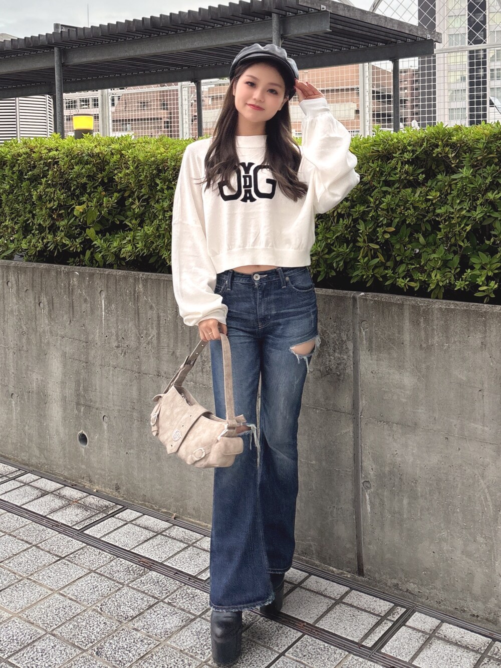 ホワイト系のニット/セーター、ブルー系のデニムパンツ、ベージュ系のショルダーバッグを着用したレディースの秋コーディネートの2枚目の写真