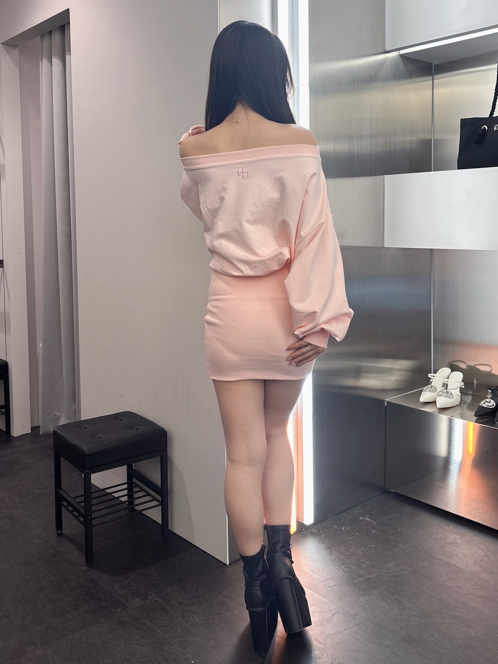 ピンク系のワンピース、ブラック系のブーツを着用したレディースの春コーディネートの3枚目の写真