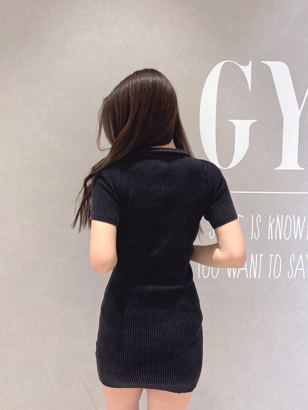 ブラック系のワンピース、ブラック系のブーツを着用したレディースの春コーディネートの6枚目の写真