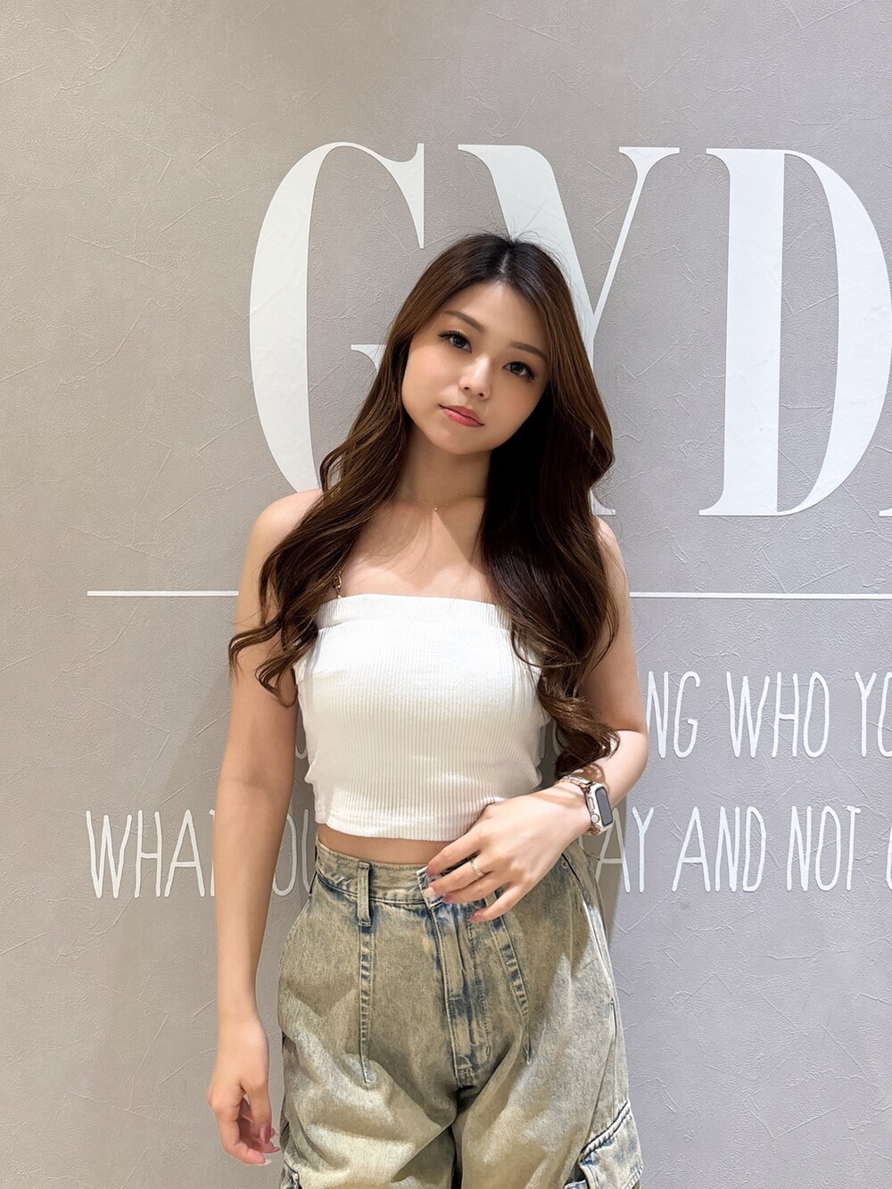 ホワイト系のキャミソール、ブラック系のサンダル、ブルー系のデニムパンツを着用したレディースの夏コーディネートの4枚目の写真