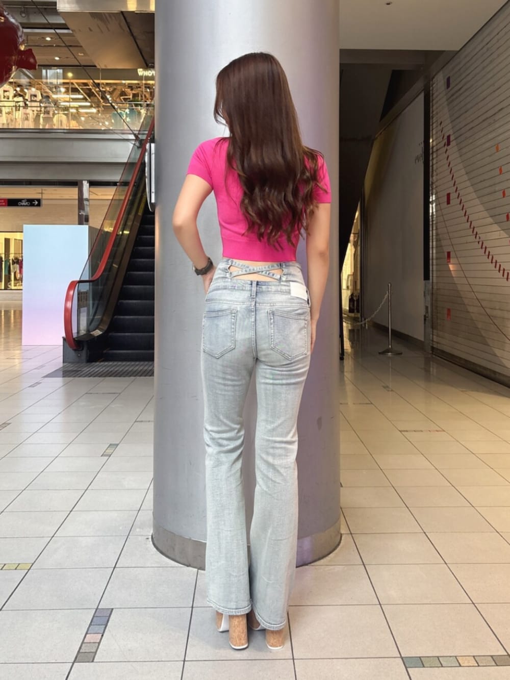 ブルー系のデニムパンツ、ホワイト系のサンダル、ピンク系のニット/セーターを着用したレディースの夏コーディネートの3枚目の写真