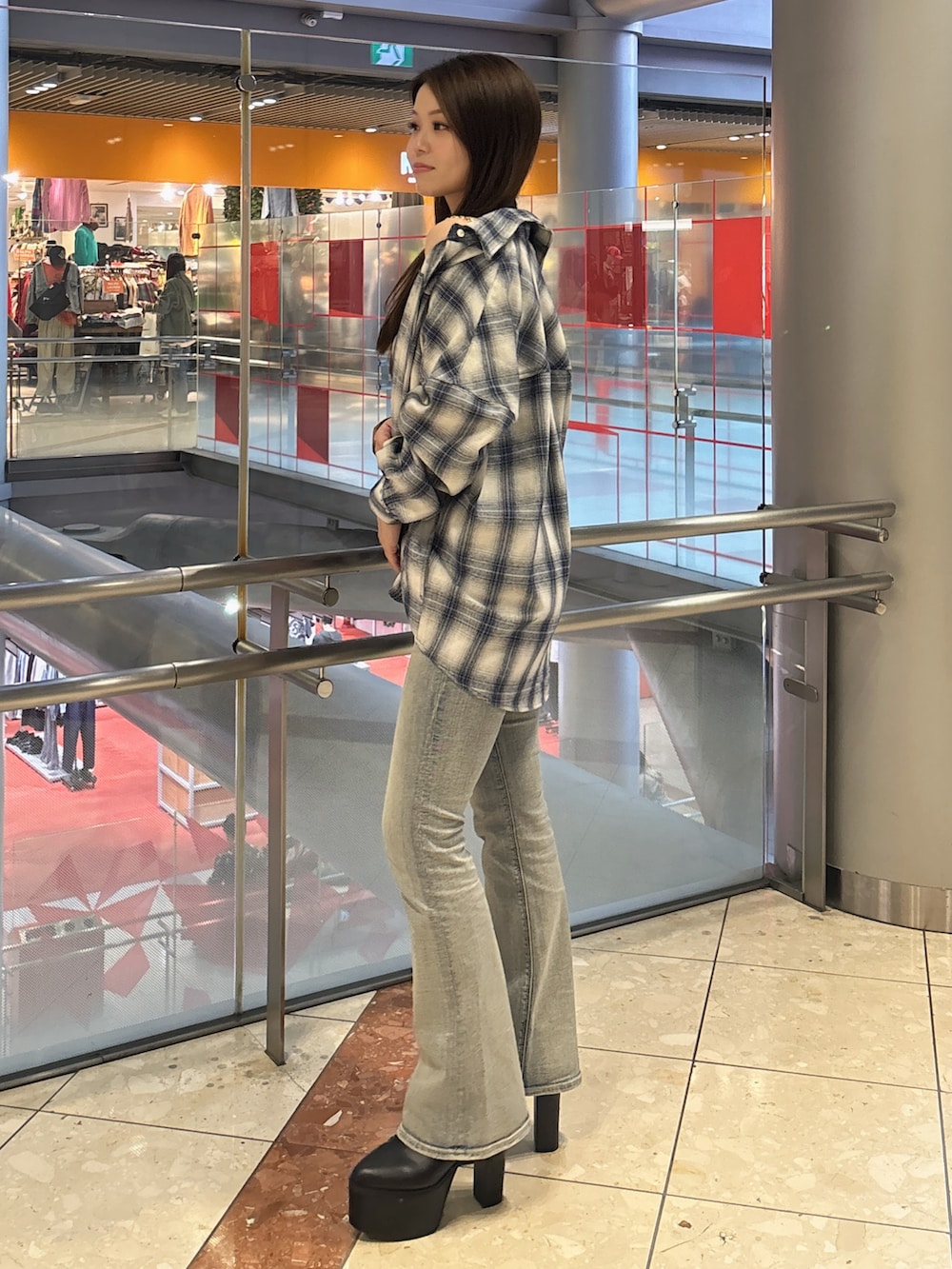 ホワイト系のキャミソール、ブルー系のデニムパンツ、ブラック系のブーツを着用したレディースの春コーディネートの2枚目の写真