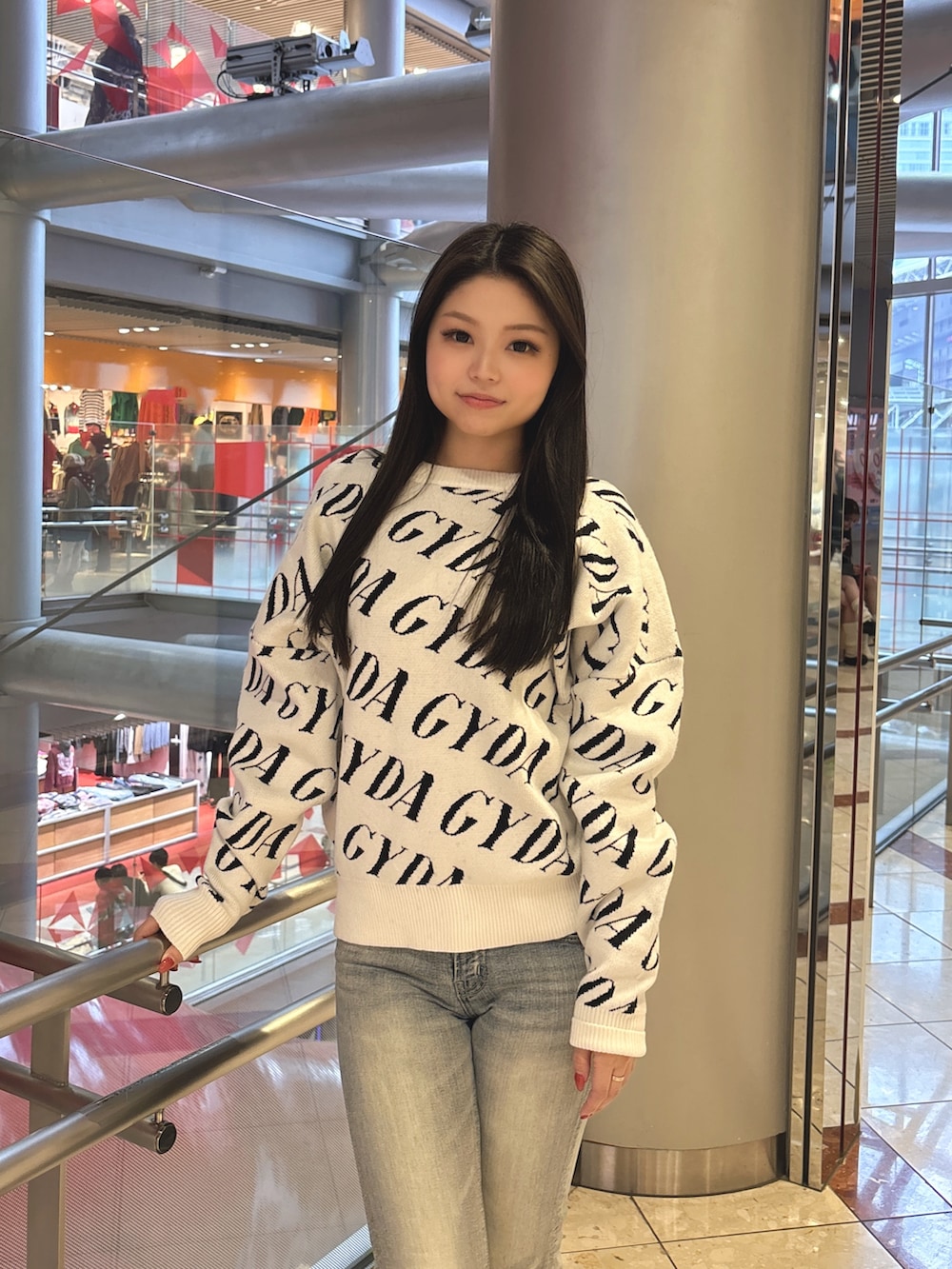 ブラック系のニット/セーター、ブルー系のデニムパンツ、ブラック系のブーツを着用したレディースの春コーディネートの4枚目の写真