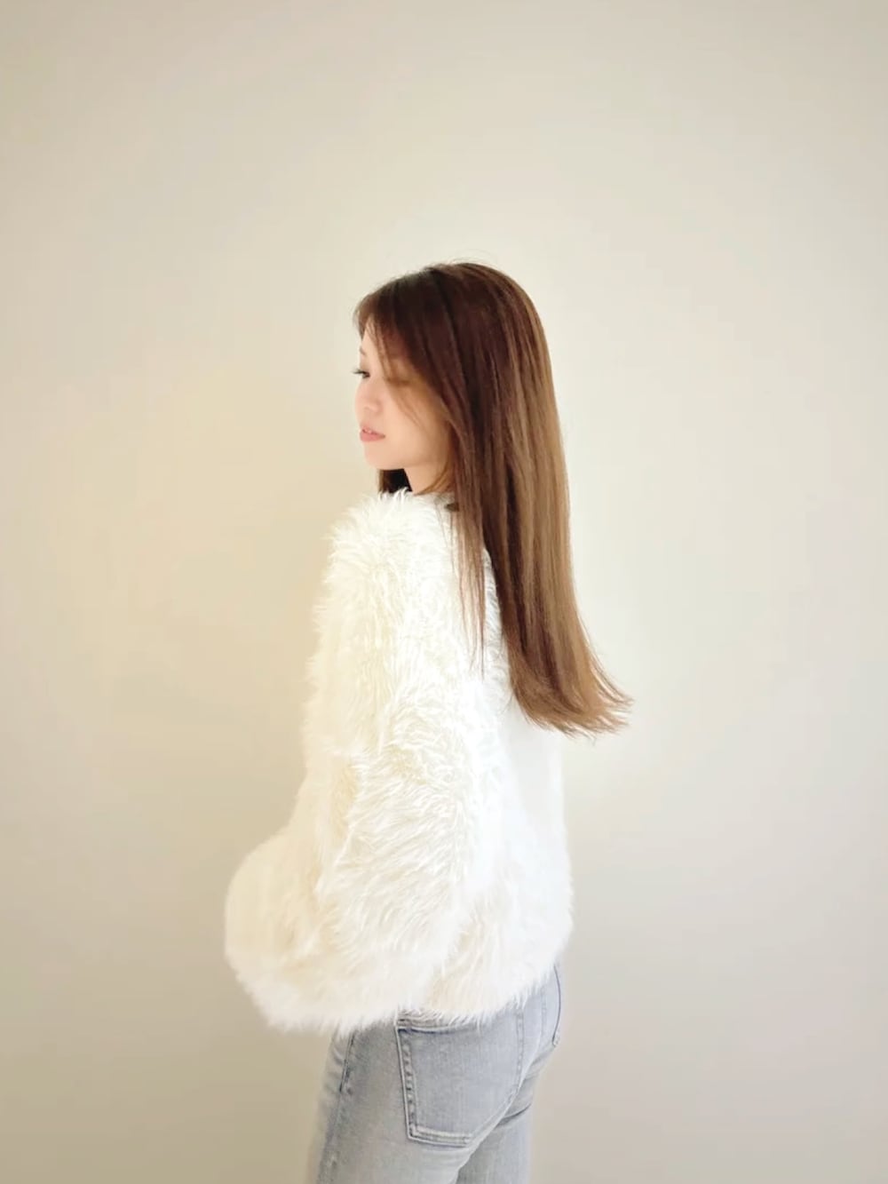 ホワイト系のカーディガン/ボレロ、その他のニット/セーター、ブルー系のデニムパンツを着用したレディースの秋コーディネートの6枚目の写真